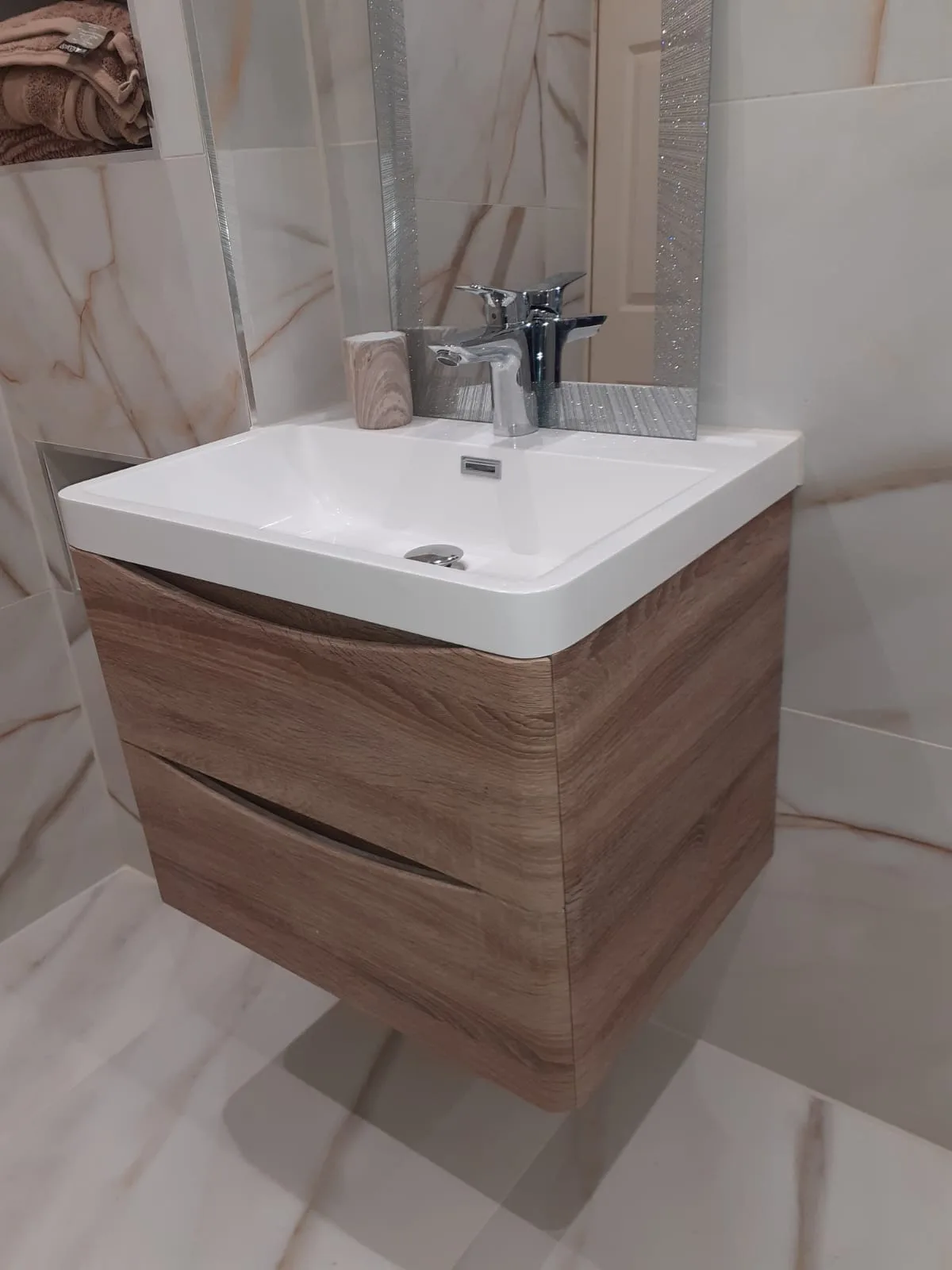 Basin and vanity unit fitted in a marble tiled bathroom